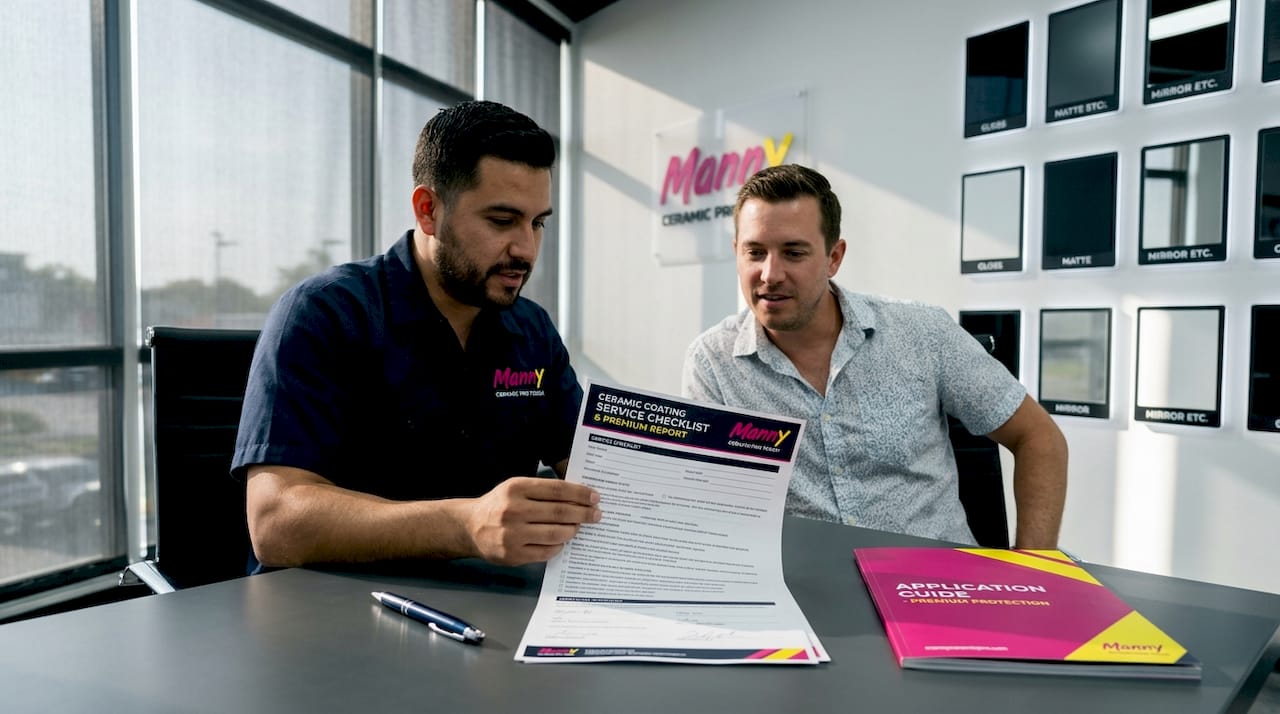 Technician consulting with car owner in office