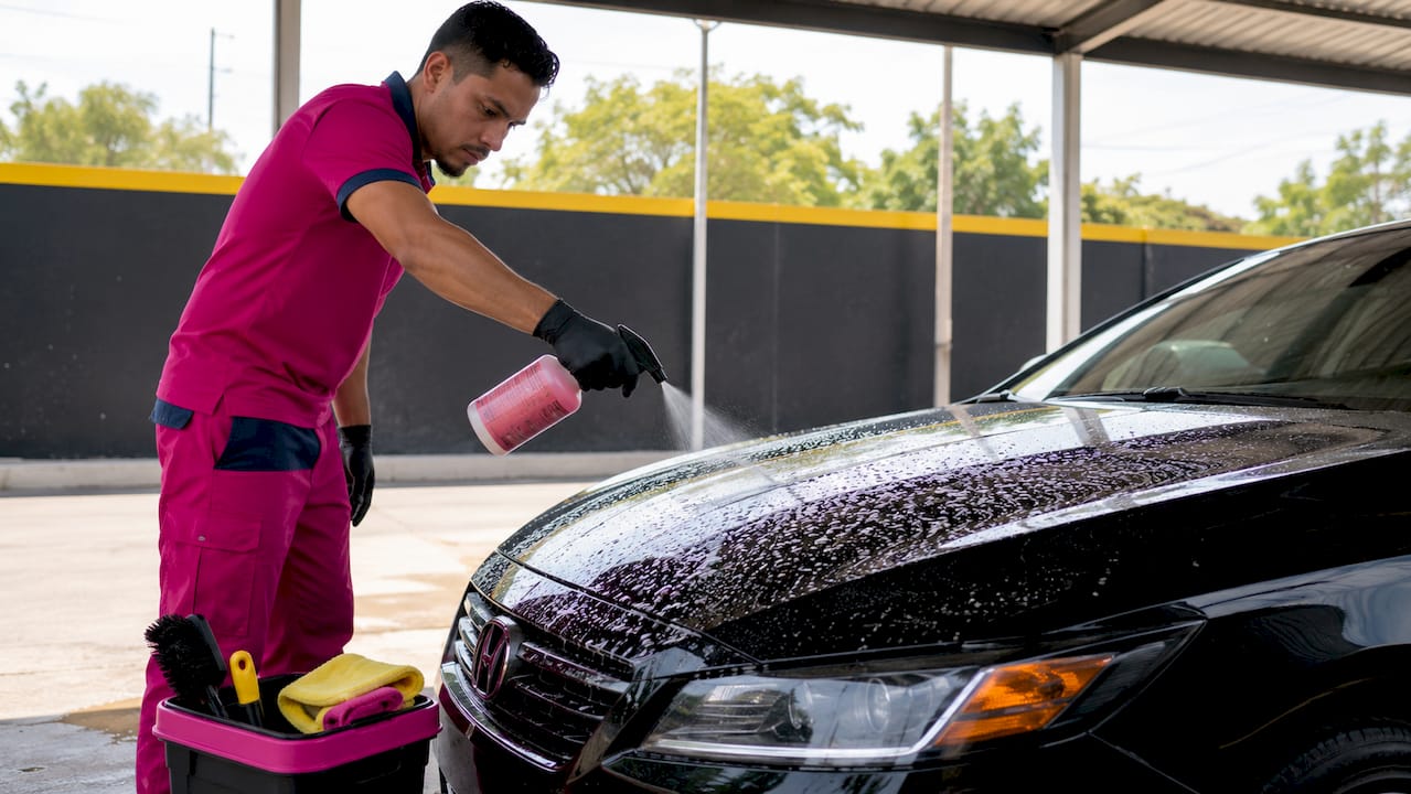 Technician applying iron remover on car paint
