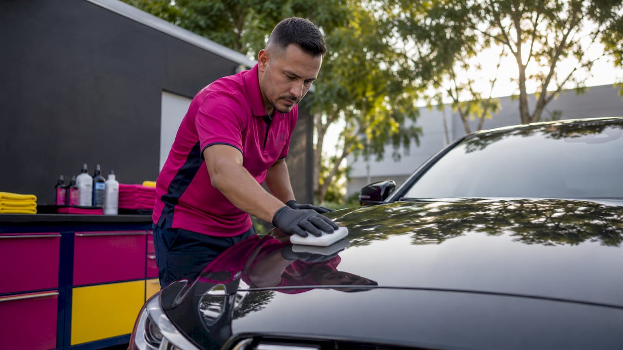 Detailer applying hydrophobic coating on car