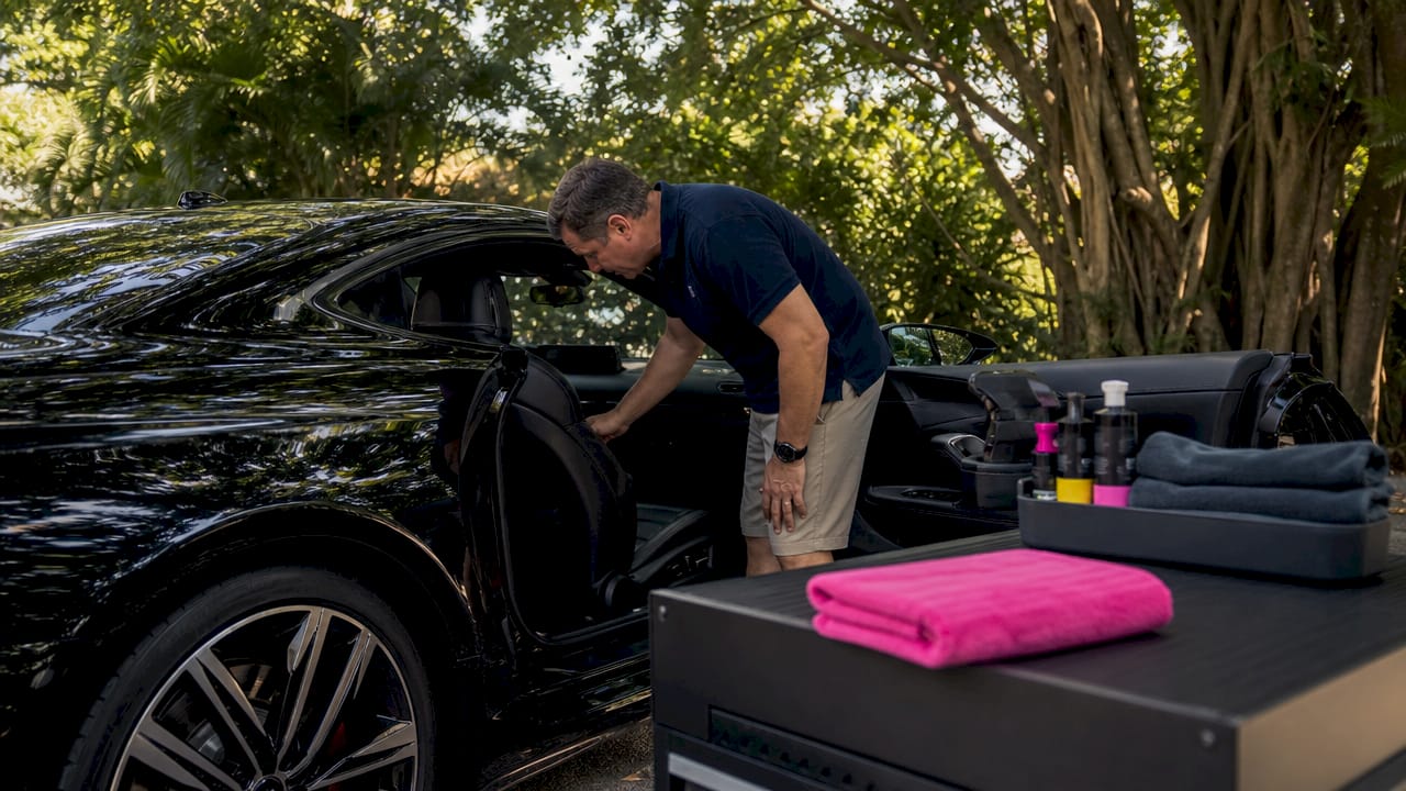 Man inspecting luxury vehicle interior in garage