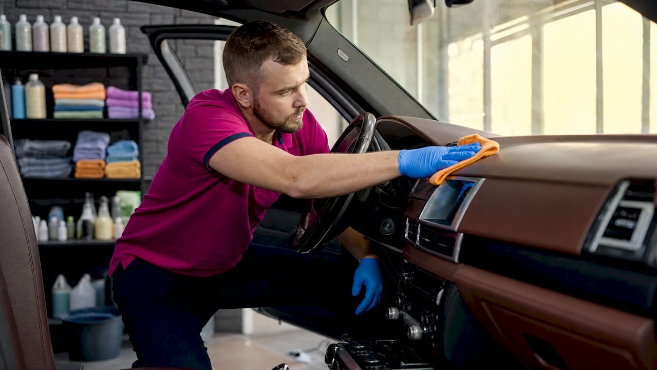 Detailer cleaning luxury car dashboard