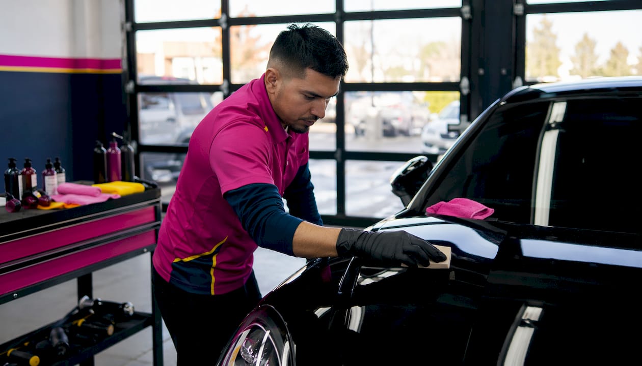 Detailer applying ceramic paint protection to car hood