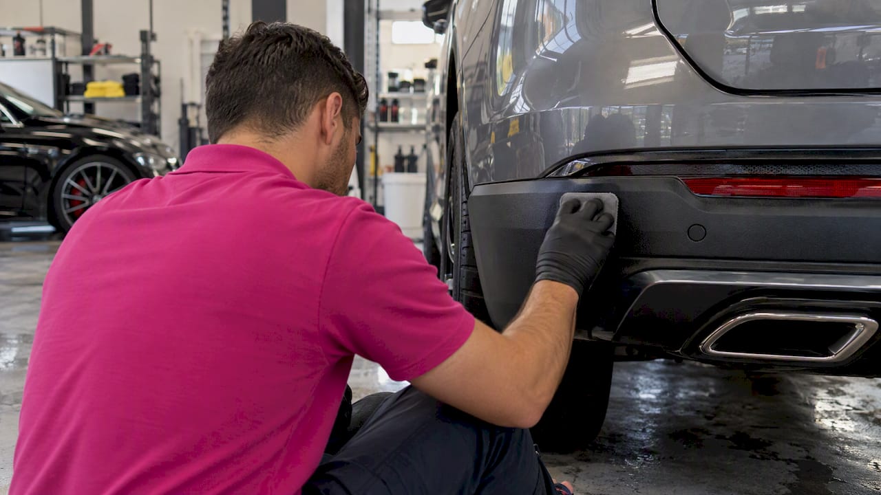Technician coating luxury car trim